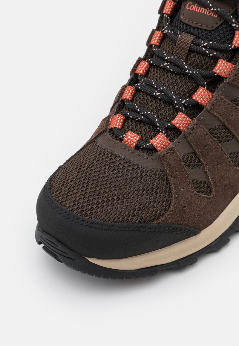 Scarpa da trekking marrone con tomaia in rete e dettagli in suede, punta in gomma nera e lacci arancioni con dettagli riflettenti.