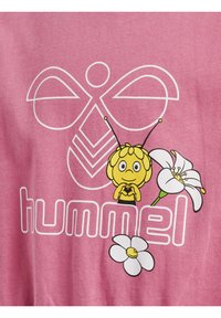 Rosa Baumwoll-T-Shirt mit einem Grafik-Design eines Cartoon-Bienen, weißen Blumenakzenten und dem Text "hummel" in fetten, abgerundeten Buchstaben.