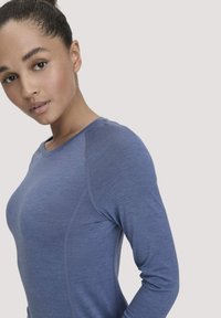 Langsleeve blauwe top van zachte, gestructureerde stof, met een ronde halslijn en raglanmouwen, en subtiele naaddetails.