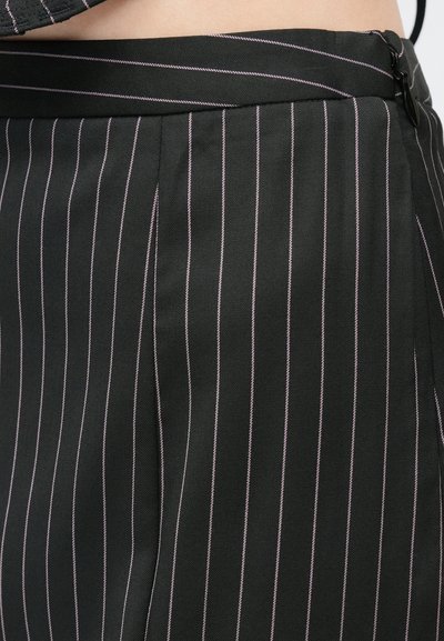 Juodas audinys su vertikaliomis rožinėmis juostelėmis, turintis juosmenį, klostes ir šoninio užtrauktuko. Lygi tekstūra, oficialaus dizaino.