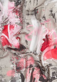 Satin šalle ar abstraktu dizainu, kurā ir rozā, sarkanas un pelēkas otas triecieni uz gaiši bēša fona, demonstrējot gludu tekstūru.