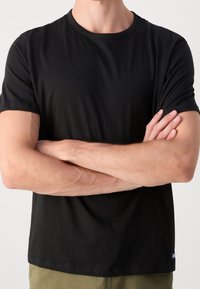 Sort bomulds T-shirt med korte ærmer, rund hals og en afslappet pasform; har et lille blåt logo på nederste venstre kant.