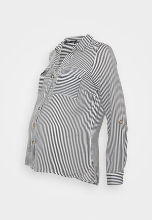 Sort og hvid, lodret stribet graviditetsskjorte med lange ærmer, brystlommer og knaplukning på en hvid baggrund.