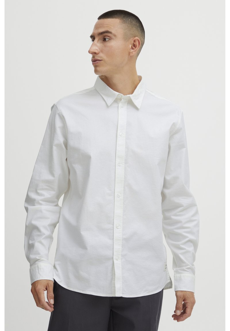 Hvid langærmet skjorte med knapper lavet af bomuld. Har en klassisk krave, lige kant og en afslappet pasform. Minimalistisk design.