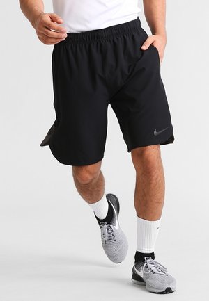 Pantalones cortos deportivos negros hechos de una tela ligera con una cintura elástica, aberturas laterales para mayor movilidad y un pequeño logo de Nike en la pierna izquierda.