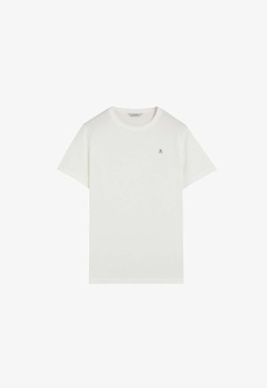 T-shirt blanc à manches courtes et col rond avec un petit logo tête de mort et os croisés sur la poitrine gauche.
