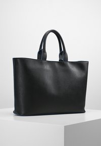 Czarna torba tote z gładką, teksturowaną powierzchnią, niebieskimi akcentami wzdłuż krawędzi i dwoma solidnymi uchwytami. Prostokątny kształt, przestronne wnętrze.