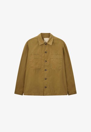 Veste à manches longues de couleur beige, fabriquée en tissu léger, avec un col pointu, une fermeture à boutons sur le devant et deux poches poitrine.