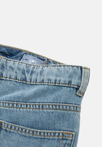 Jeans de mezclilla azul claro con cintura alta, con costuras amarillas, cierre de botón y un bolsillo visible en la parte posterior.