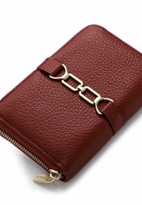 Burgundy leather wallet with textured finish, gold-tone chain accent, zip closure, and rectangular shape. Features a strap with a decorative clasp.