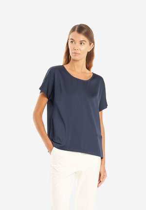 Mørkeblå kortærmet bluse med en afslappet pasform, rund halsudskæring, blødt stof og minimalistisk design. Kombinationen med lyse bukser.