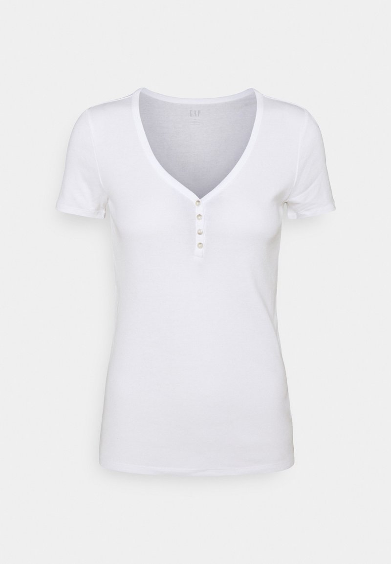 T-shirt blanc en coton avec un col en V, des manches courtes et un détail de cinq boutons à l'avant. Texture lisse, coupe classique.