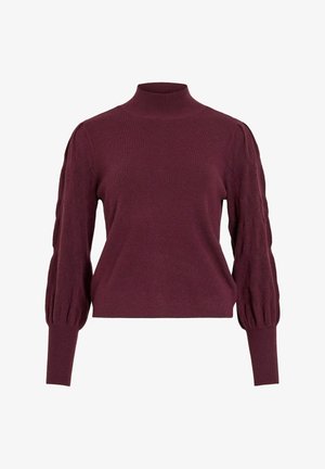 Vīna sarkans adīts džemperis ar augstu apkakli, pūkainām piedurknēm, kas rotātas ar teksturētu dimanta rakstu, un pieguļošām aprocēm.