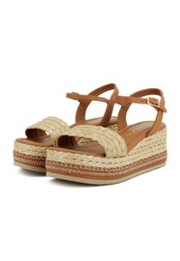 Sandalias de cuña de imitación cuero en tono marrón, con detalles de yute trenzado, correa de tobillo ajustable y suela de goma texturizada para mayor adherencia.