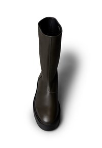 Bota hasta la rodilla de cuero caqui con textura suave, puntera redondeada y suela gruesa de goma negra. Presenta un detalle de costura vertical.