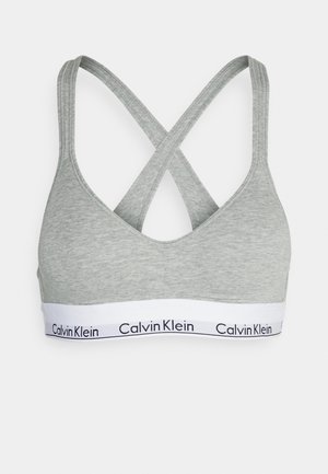 Grau Baumwolle BH mit V-Ausschnitt, gekreuzten Trägern und einem weißen Bund mit schwarzer "Calvin Klein"-Markierung. Weiches, figurbetontes Design.