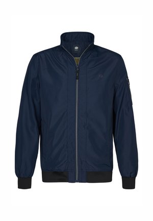 Veste coupe-vent navy avec un col montant, fermeture éclair à l'avant, poignets élastiques et une poche zippée sur la manche gauche. Texture lisse.