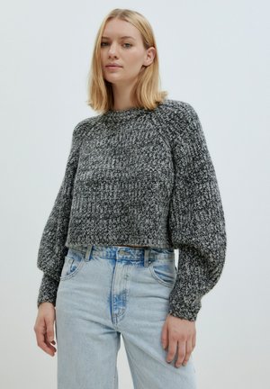 Grijze, gestructureerde gebreide pullover met een cropped ontwerp en pofmouwen, gecombineerd met lichtblauwe, high-waisted denim jeans.