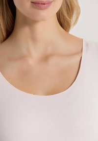 Lichtroze top met een brede ronde hals, gemaakt van soepel materiaal, met subtiele stiksels langs de rand en een aansluitende pasvorm.