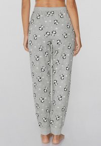 Grijze pyjamabroek van zacht materiaal, met een herhaald panda- en sterrenpatroon, voorzien van een elastische tailleband en cuffs op de enkels.
