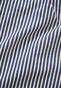 Približni prikaz tkanine s okomitim tamnoplavo-bijelim prugama, blago naborana.