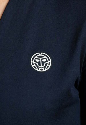 Logo bianco stilizzato di un volto al centro di un tessuto blu navy scuro, che ricorda una maschera geometrica o un emblema su un capo di abbigliamento.