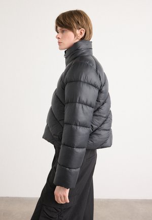 Schwarze Steppjacke mit hohem Kragen, gestepptem Design und verkürztem Schnitt. Bietet eine glatte Textur und ein Logo-Detail an der Seite.