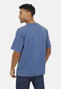 Blauwe katoen T-shirt met korte mouwen, voorzien van een ronde hals, rafelrand en een relaxte pasvorm. Opvallende textuur met een vervaagde wassing.