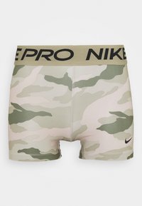 Beige and green camouflage Nike Pro compression shorts with wide beige waistband and black Nike Pro logo, small black Nike swoosh on leg.