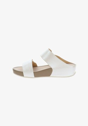 Sandaletto bianco con punta aperta, due ampie fasce, suola piatta e cinturino posteriore di supporto, mostrato di profilo su sfondo bianco.