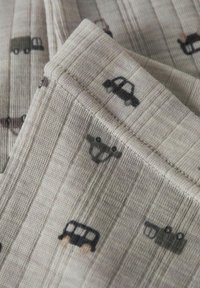 Un tissu gris clair présente une texture nervurée avec un motif répété de petites voitures en noir, gris et marron.