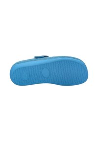 Chausson bleu avec une texture douce, une semelle en caoutchouc flexible avec un motif texturé, et un petit logo circulaire près du talon.