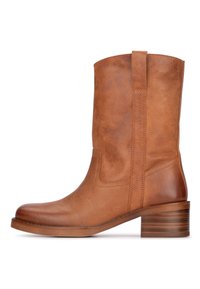 Bottine en cuir marron, avec un bout arrondi, une texture lisse et un talon bas empilé. Présente des coutures latérales et une languette pour un enfilage facile.