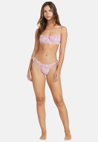 Two-piece bikini in light pink fabric featuring a floral pattern. The top has a straight neckline, and the bottoms have adjustable side ties.