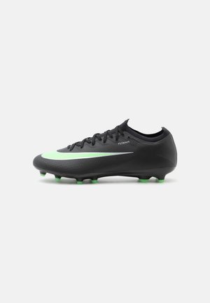 Čierny futbalový kopačka Nike Flyknit so zelenými kolíkmi a veľkým svetlozeleným logom Nike na boku.