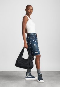 Denim rok met bloemenborduursel, witte tanktop, zwarte tas, grijze sokken, blauwe hoge sneakers, gladde textuur, casual stijl.