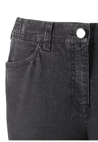 Jeans en denim noir avec une finition texturée. Les caractéristiques incluent une fermeture à bouton à l'avant, des passants de ceinture et des poches latérales.