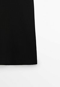 Gonna nera in tessuto, texture liscia, taglio al ginocchio, senza motivi visibili, orlo semplice. Adatta per diverse opzioni di abbinamento.