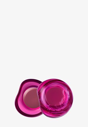 Récipient rond translucide rose vif avec un couvercle ouvert assorti montrant une crème de couleur mauve à l’intérieur sur fond blanc.