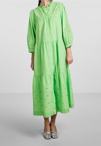 Abito midi in cotone verde con apertura a bottoni sul davanti, colletto arricciato e dettagli a occhiello. Caratterizzato da un design a strati e orlo ondulato.