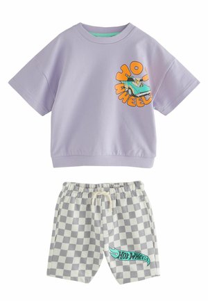 Camicia lilla a maniche corte con grafica di un'auto stampata e testo arancione, abbinata a pantaloncini a quadri con logo "Hot Wheels" turchese.