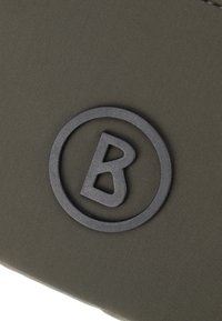 Olive zelena tkanina torbica z črnim okroglim logotipom s kapitalno črko 'B' v središču. Gladka tekstura z našitjem ob robovih.
