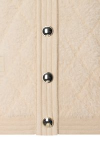 Beige textiel met een verticale ribstructuur en drie glanzende zilveren drukknoopjes in een close-up weergave.
