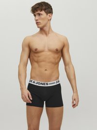 Schwarze Boxershorts mit einem weißen elastischen Bund, auf dem "JACK & JONES" gedruckt ist. Aus Baumwollmaterial, mit taillierter Passform und kurzem Bein.
