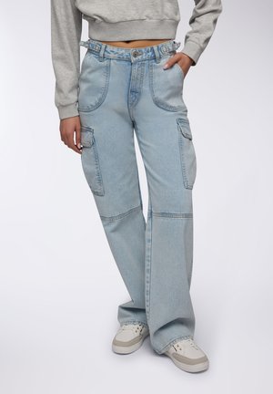 Jeans cargo azzurri chiari con gambe larghe, tasche frontali e vita con passanti per cintura. Realizzati in denim con un lavaggio sbiadito.