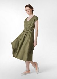 Vestido de algodón verde olivo con escote en V y mangas cortas, con cintura elástica y falda acampanada. Combinado con zapatillas en tonos pastel.