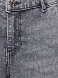 Detailní záběr šedých riflí z denimu zobrazující knoflík, pas, poutka na pásek a detaily šití v oblasti předních kapes.