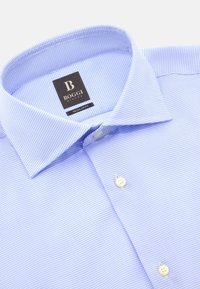 Světle modrá košile s kostkovaným vzorem, standardní střih, límeček na knoflíky a bílé knoflíky. Etiketa zní "BOGGI MILANO."