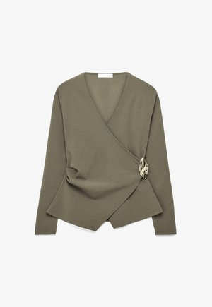 Olīvu zaļas krāsas garām piedurknēm wrap tops ar V veida izgriezumu un asimetrisku priekšpusi, kas nostiprināta ar lielu metāla dekoratīvu aizdari sānos.