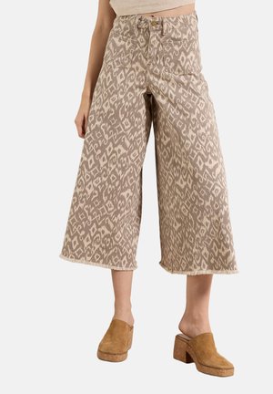 Weit geschnittene, knöchellange Hosen mit beigem und braunem abstraktem Muster, Vordertaschen, Knopfverschluss und ausgefransten Säumen, getragen mit braunen Mules mit Blockabsatz.
